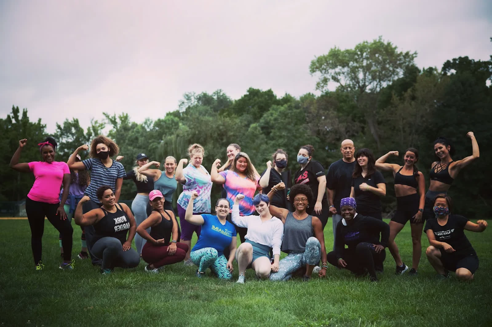 An outdoor group class flexing together after a workout
